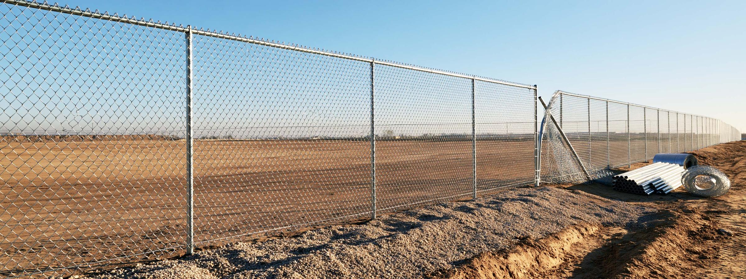 A chain link fence on a Queen Creek property with the mesh pulled away from its posts