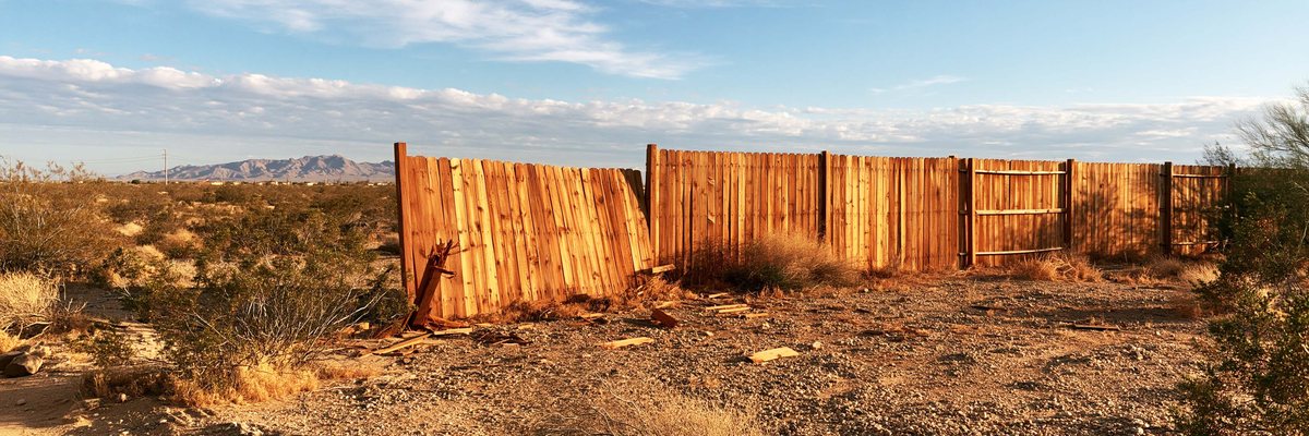 A wood fence with one section blown down after a storm, Queen Creek, AZ.